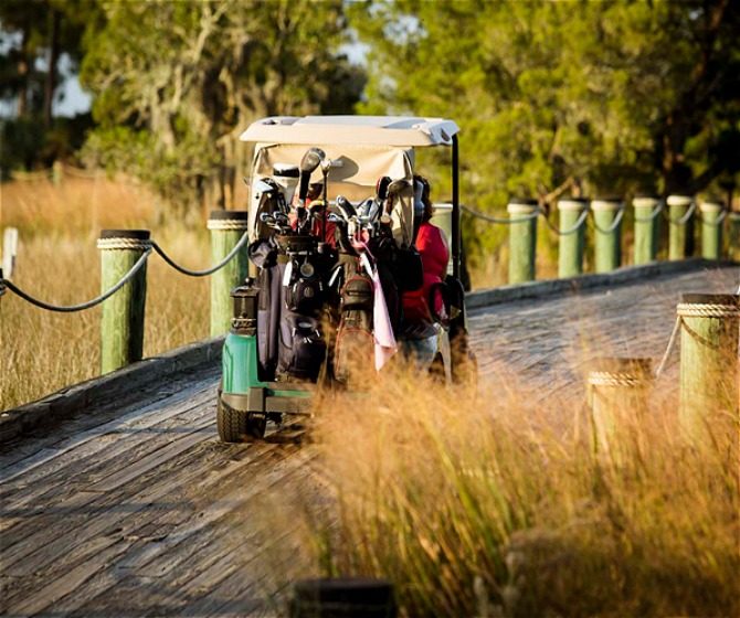 Golf course driving over wooden bridge loading=