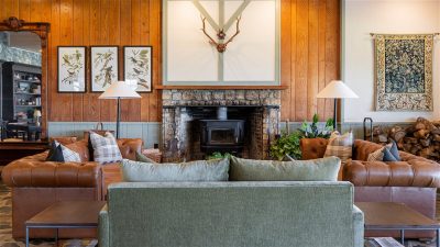 Hotel lobby with couches and various art on wood panel walls